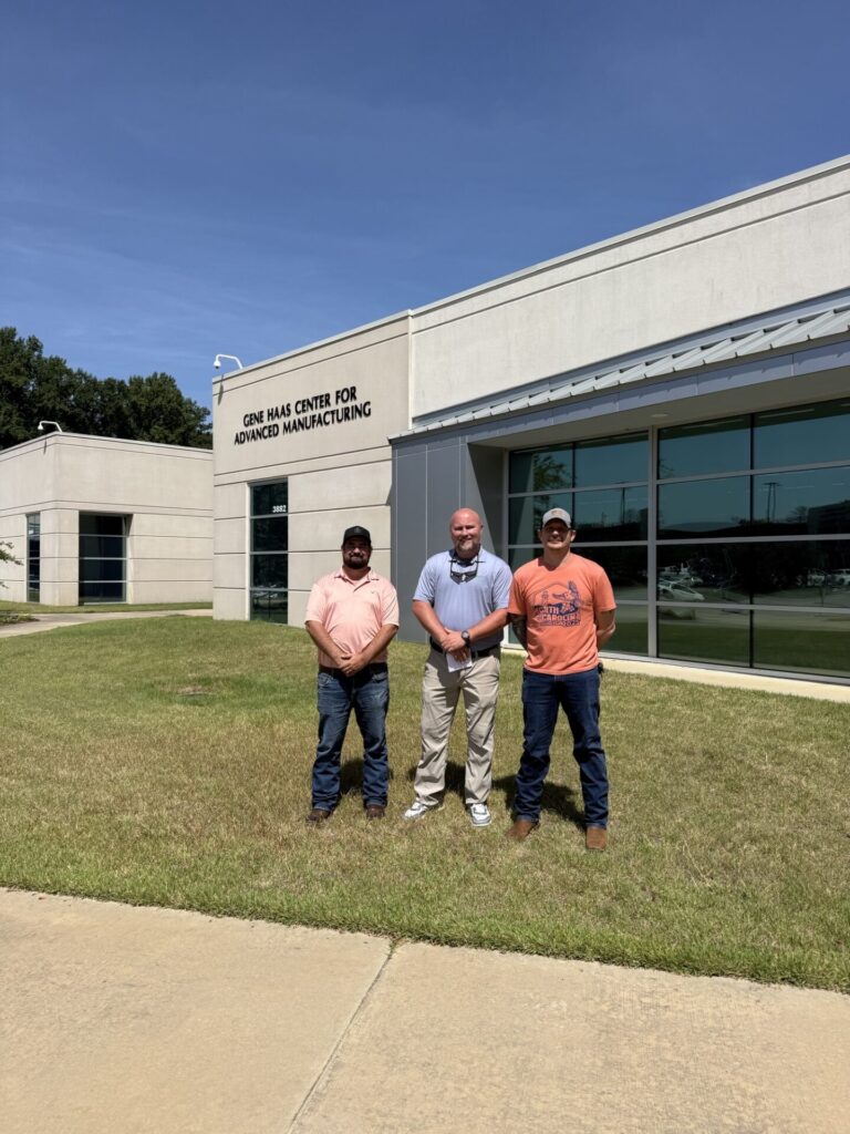 Photo of three men standing together outside of Advanced Manufacturing building.