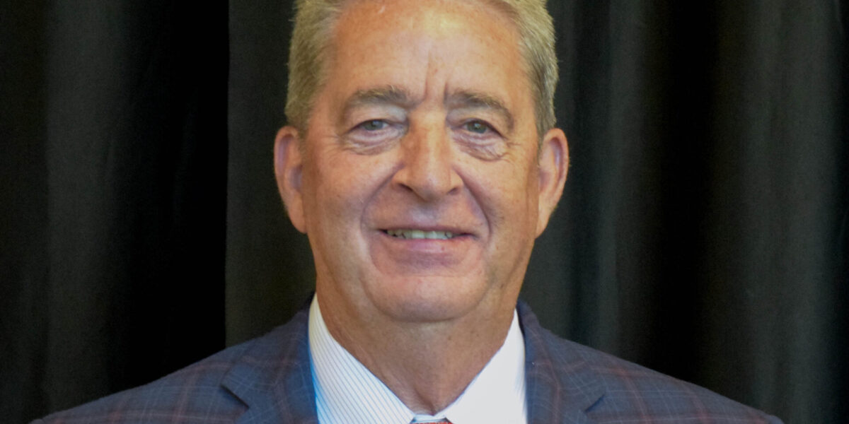 Headshot of a man in front of a black curtain